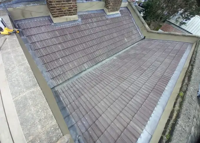 Newly tiled pitched roof between parapet walls on a London home